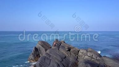 女孩剪影练习瑜伽，悬崖环绕海洋